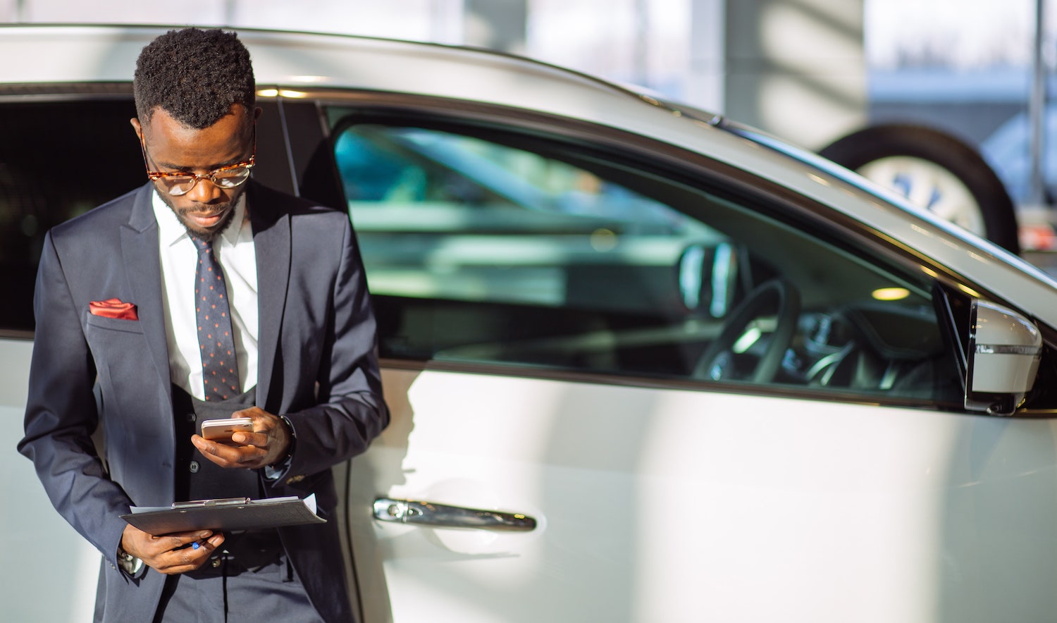car salesman using mobile device _ car rental software